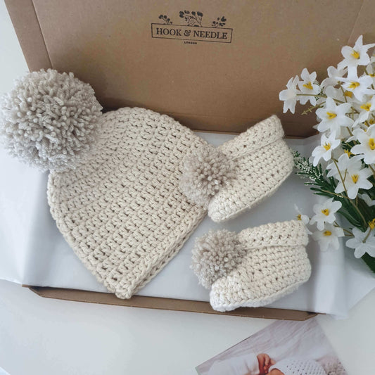 Cotton baby pom pom hat and booties in cream