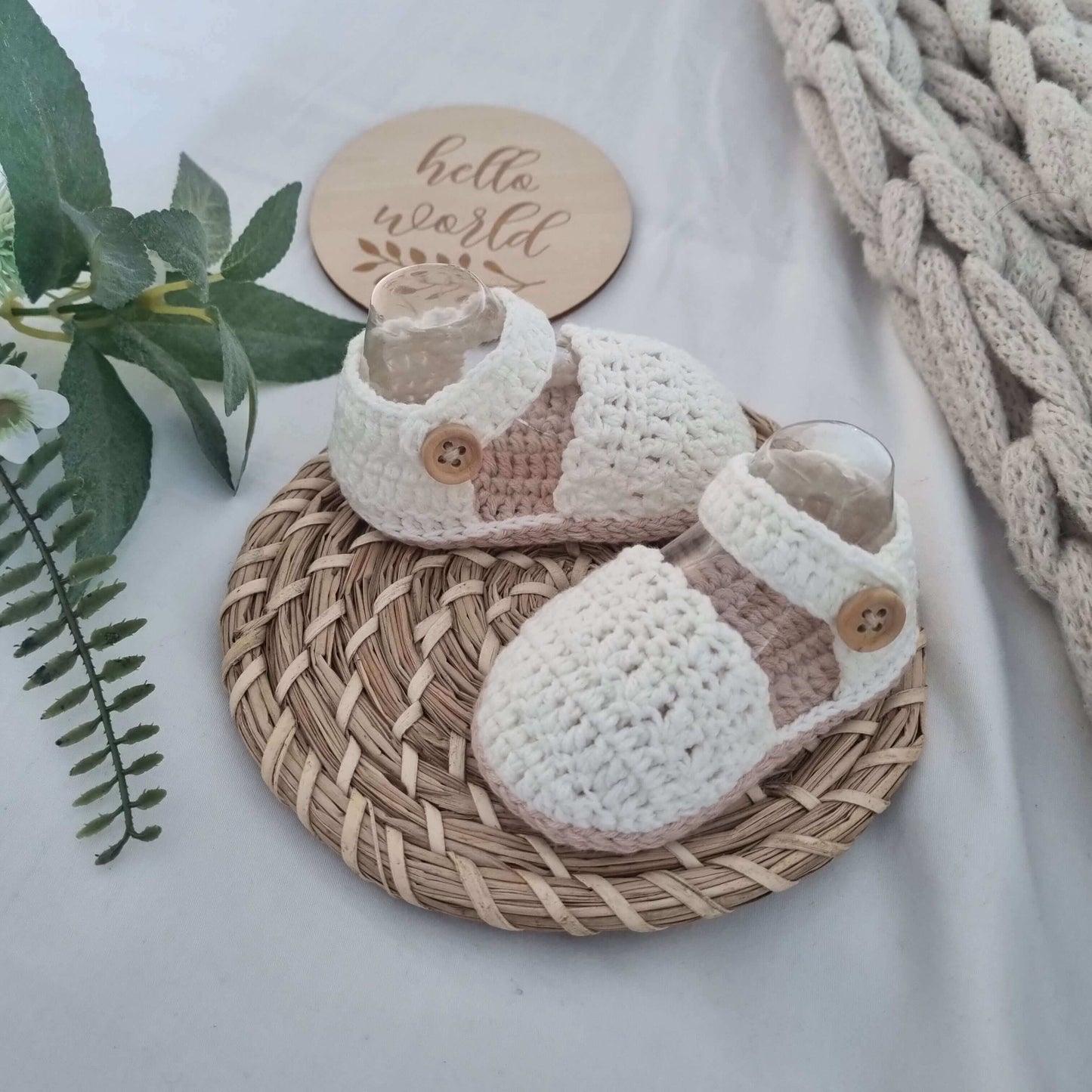 Charming baby girl crochet sandals on a wicker basket lid, beautifully crafted with a unique crochet pattern for tiny toes.