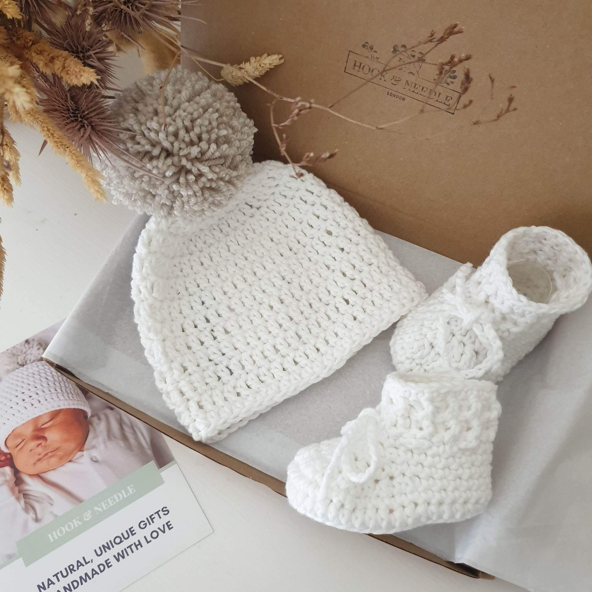 Cotton baby pom pom hat and booties in white image