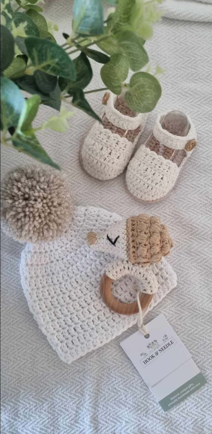 Sweet baby girl crochet sandals nestled amongst a selection of other new baby accessories. 