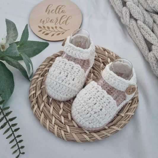 Lovely baby girl crochet sandals placed on a wicker basket lid, showcasing a cute crochet design ideal for fashionable babies