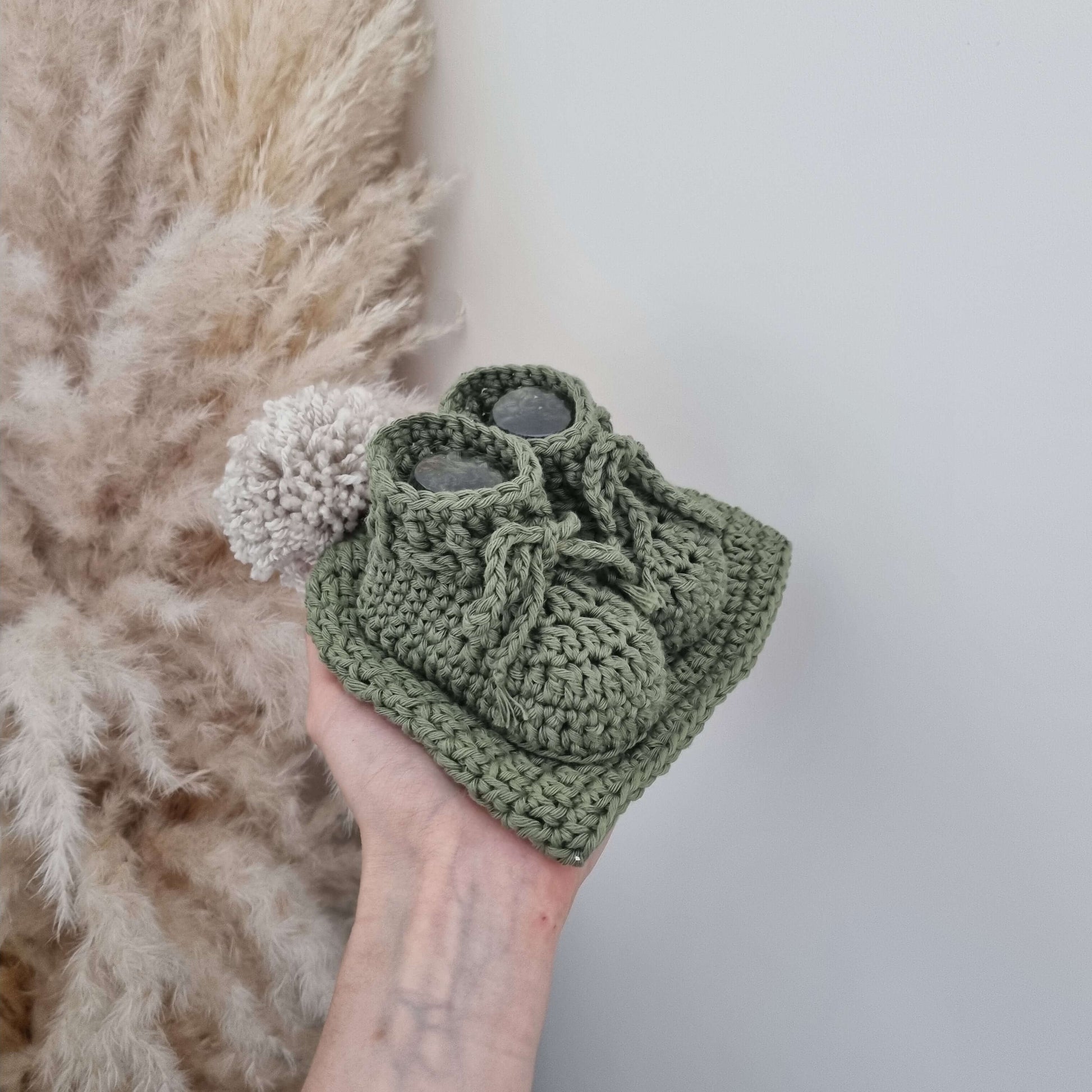 Green baby hat and boots set featuring crocheted boots and cozy design perfect for infants.