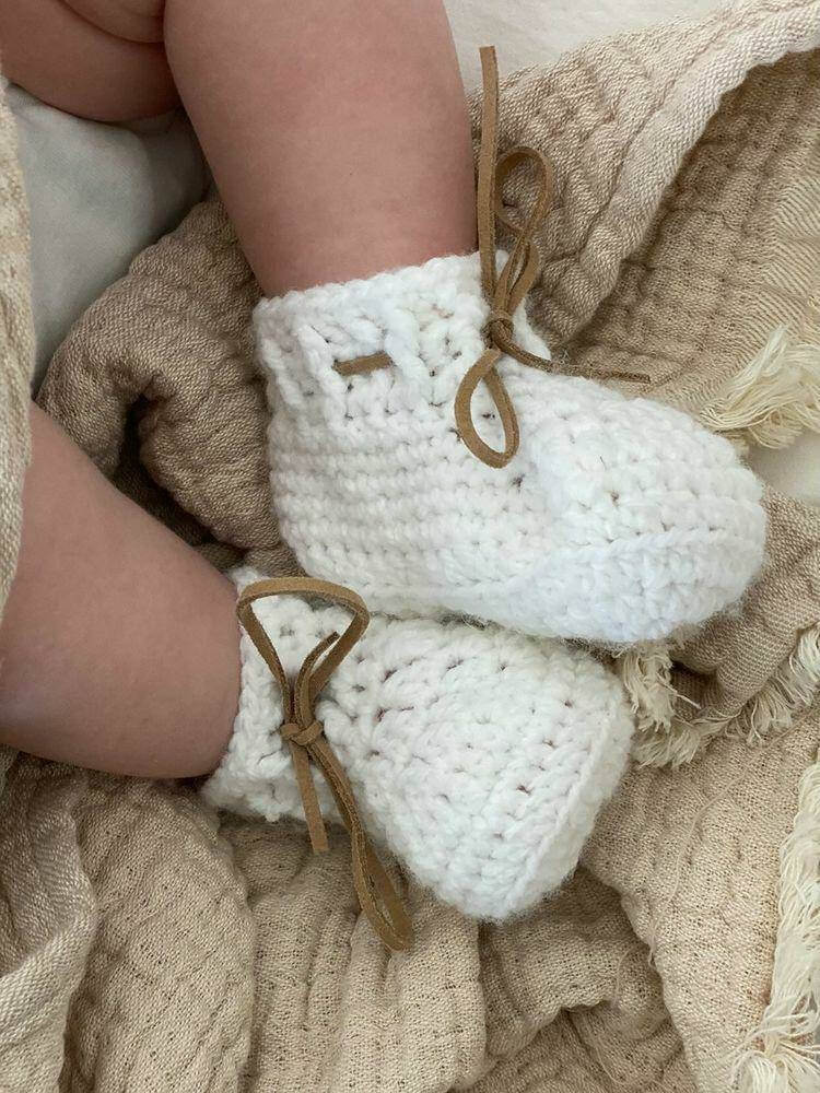 White handmade shoes on baby feet